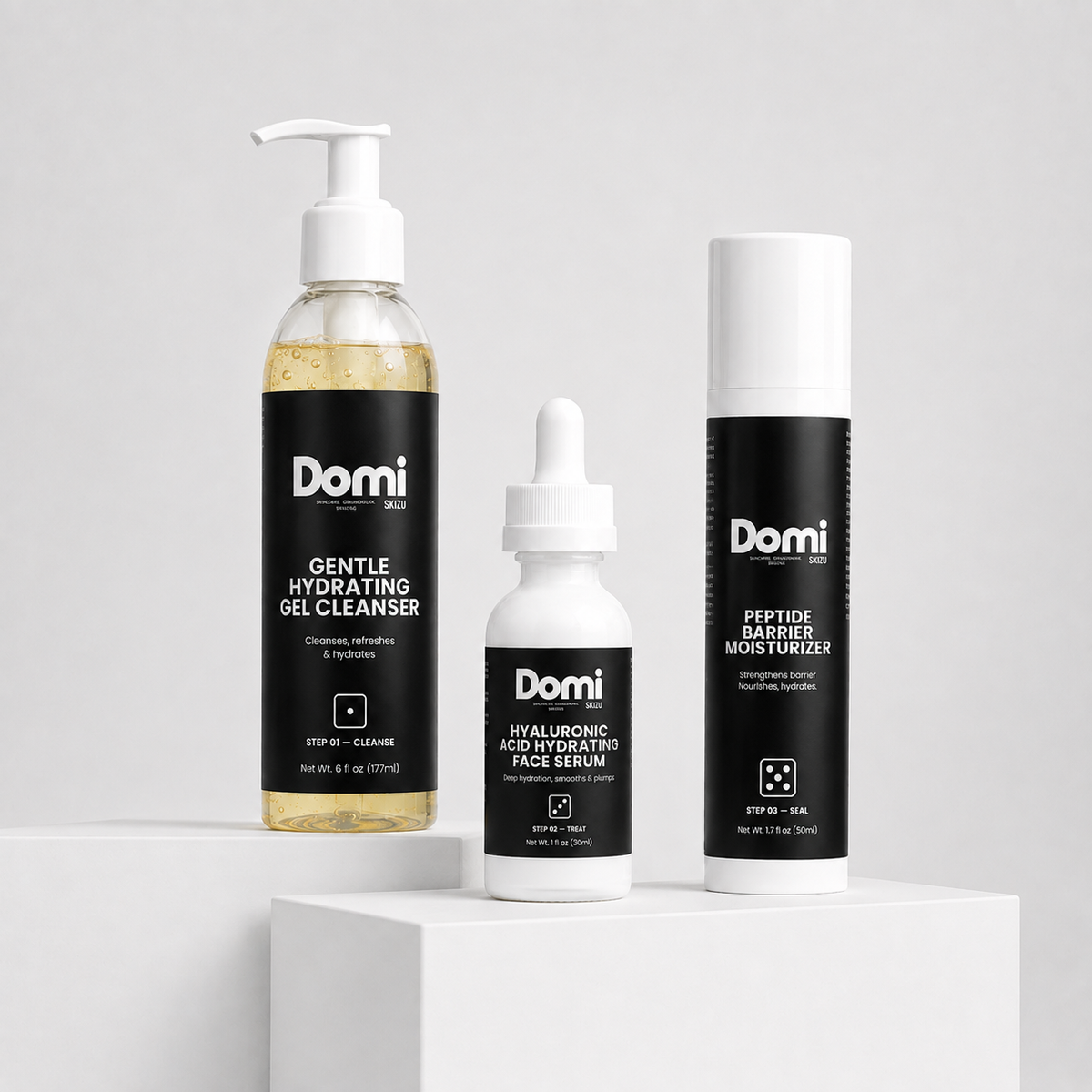 Three Domi skincare products displayed on white pedestals against a light gray background: a pump bottle of gentle hydrating gel cleanser, a dropper bottle of hyaluronic acid hydrating face serum, and a cylindrical tube of peptide barrier moisturizer.